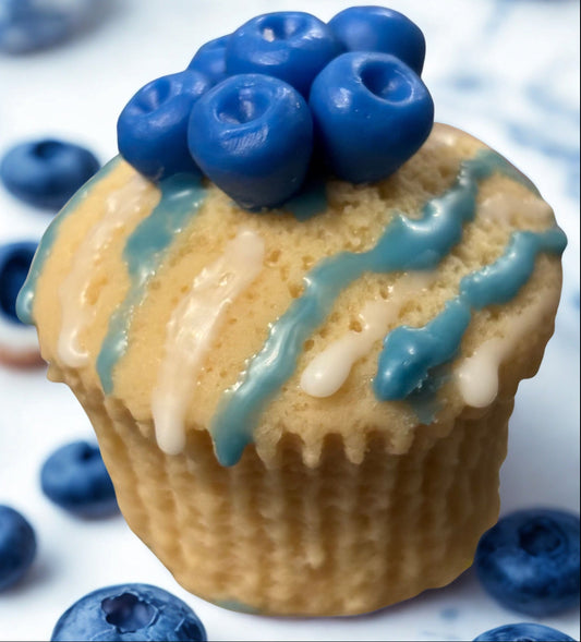 Muffin with blueberry topping and blue icing on a white background